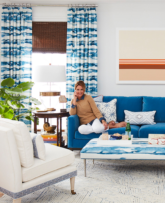 Living room set in blue and orange with female model on sofa